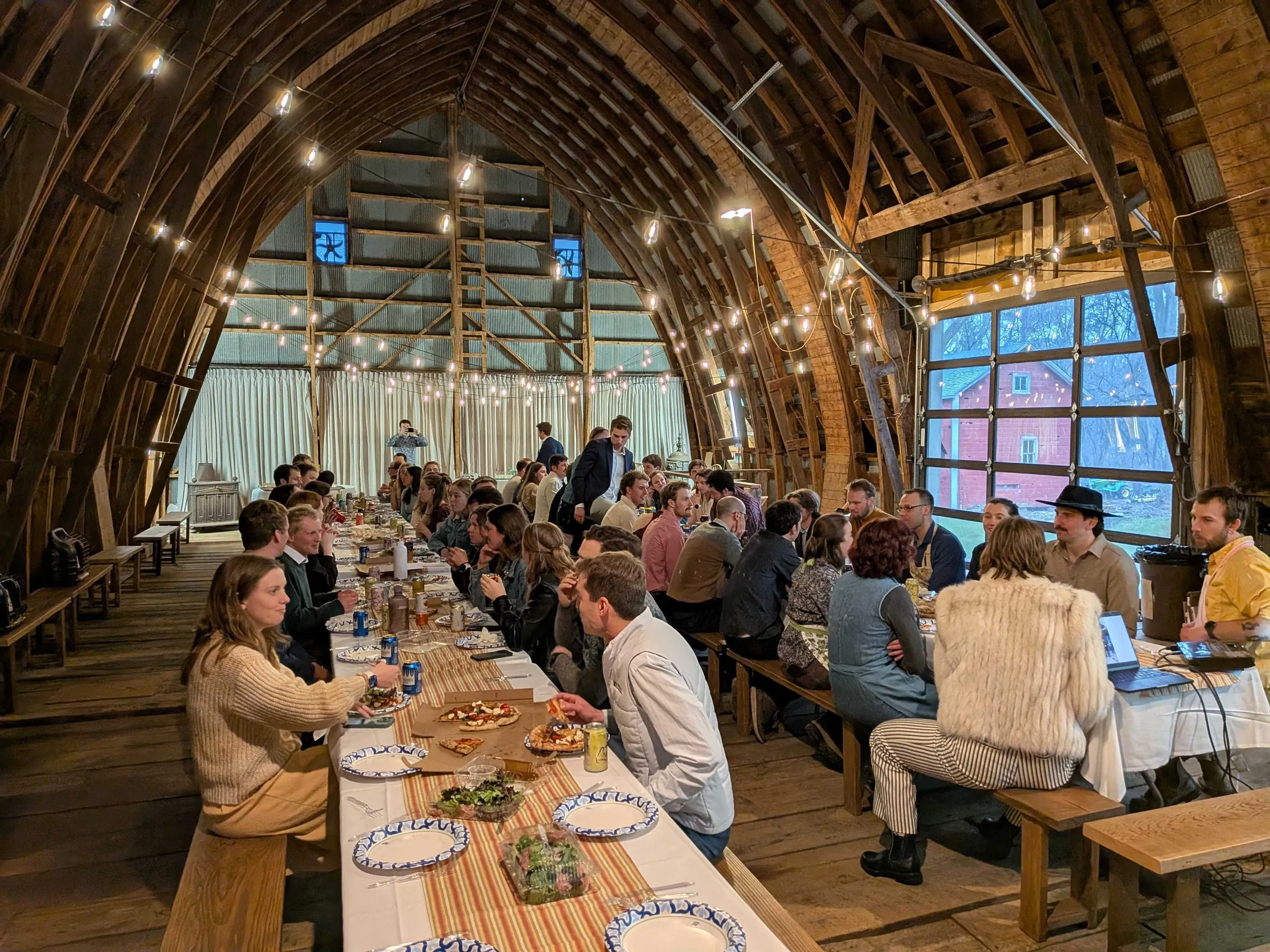 The club banquet in a barn venue strung with lights, every table full