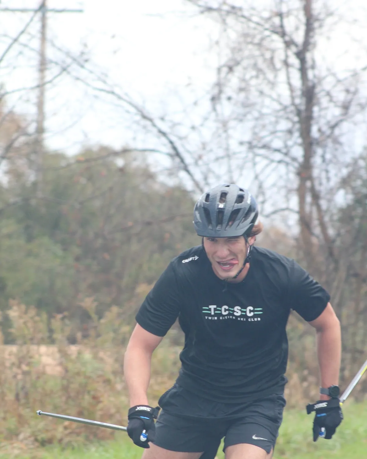 A racer in a TCSC jersey at full effort on the rollerski leg