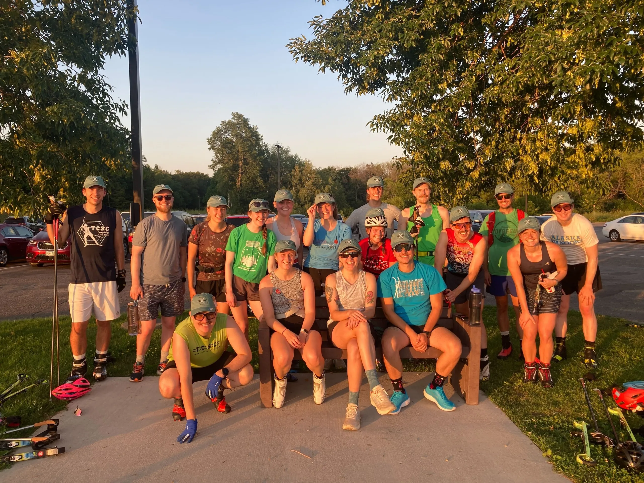 A line of members rollerskiing together at golden hour, poles mid-swing