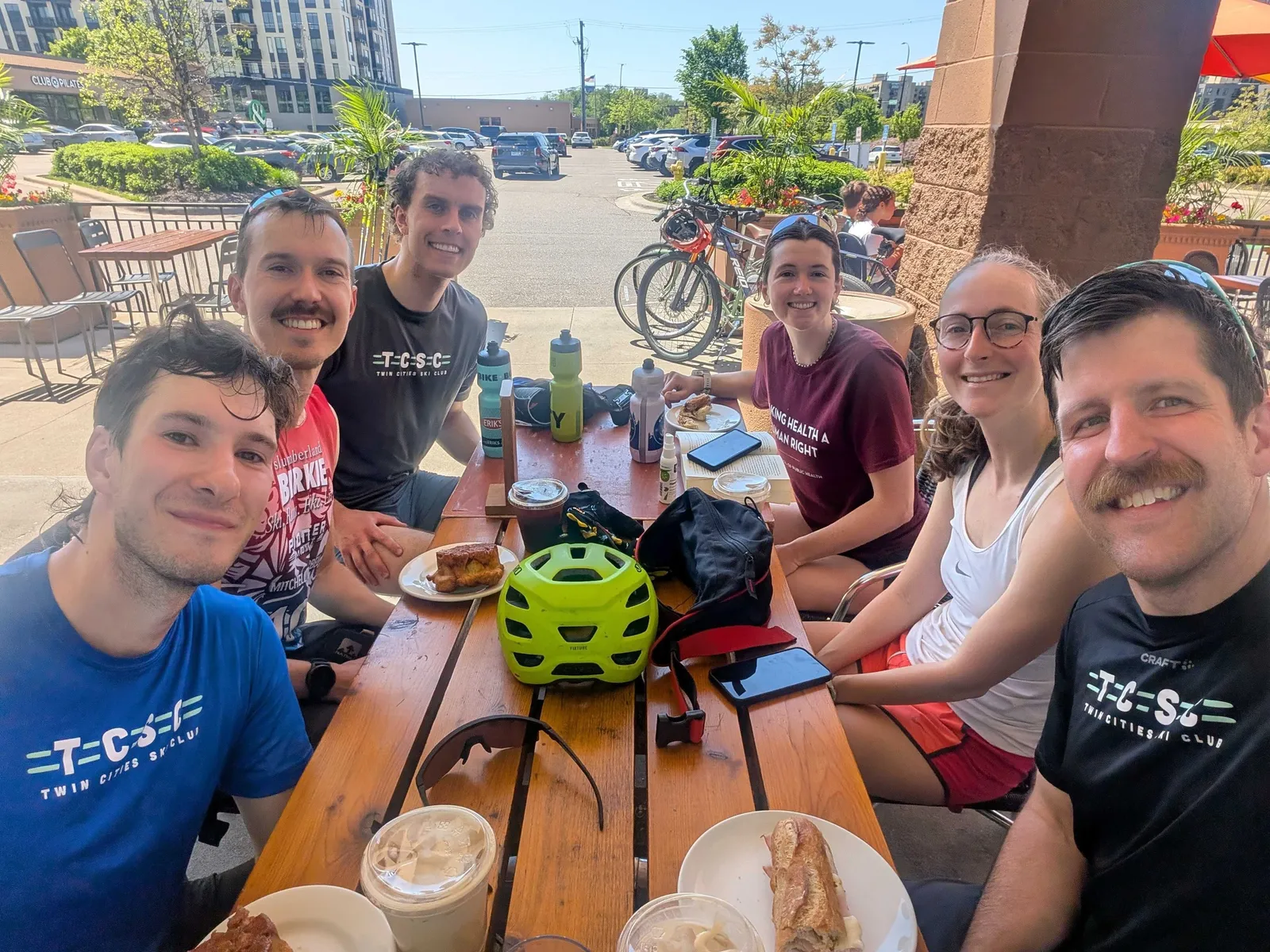 Helmeted rollerskiers gathered around post-practice treats