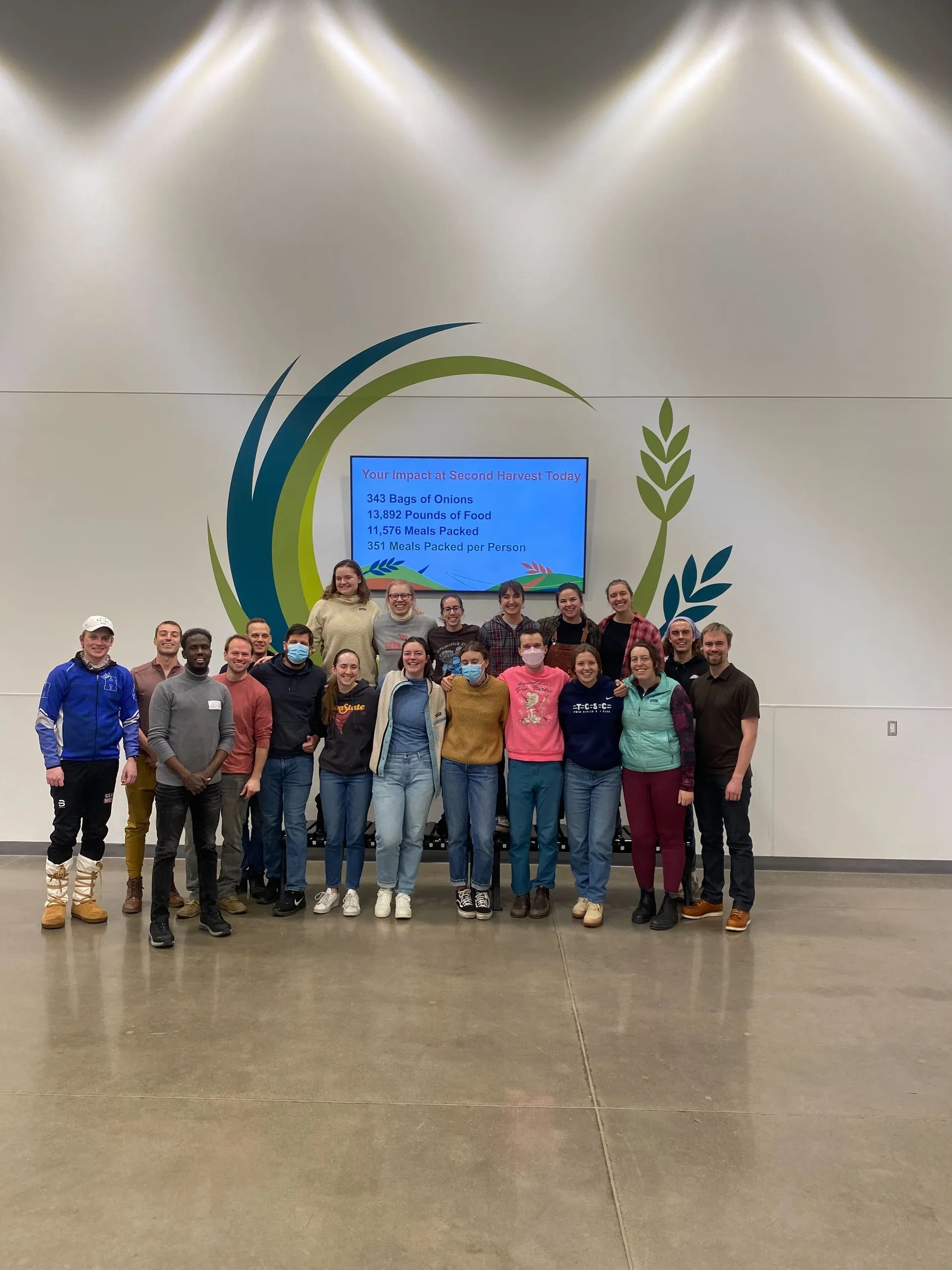 Members posing together at a Second Harvest food-packing volunteer night